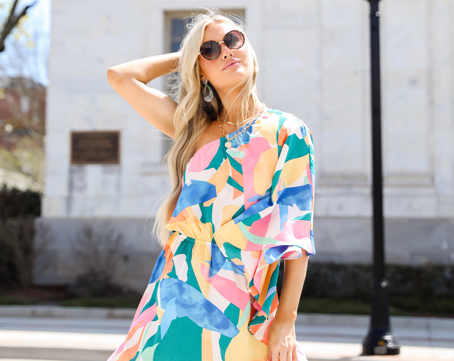 model wearing a colorful one-shoulder midi dress