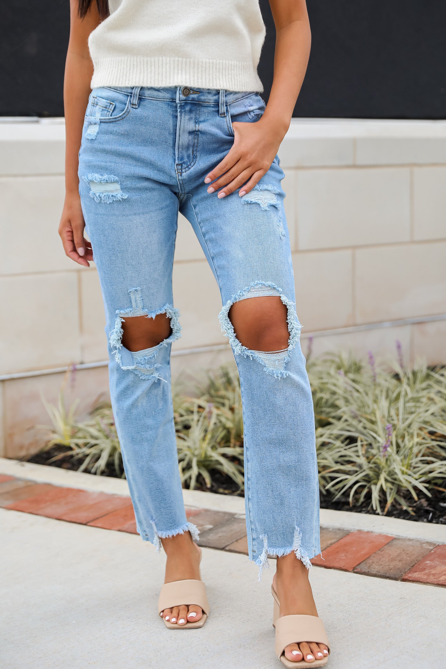 model wearing distressed denim jeans