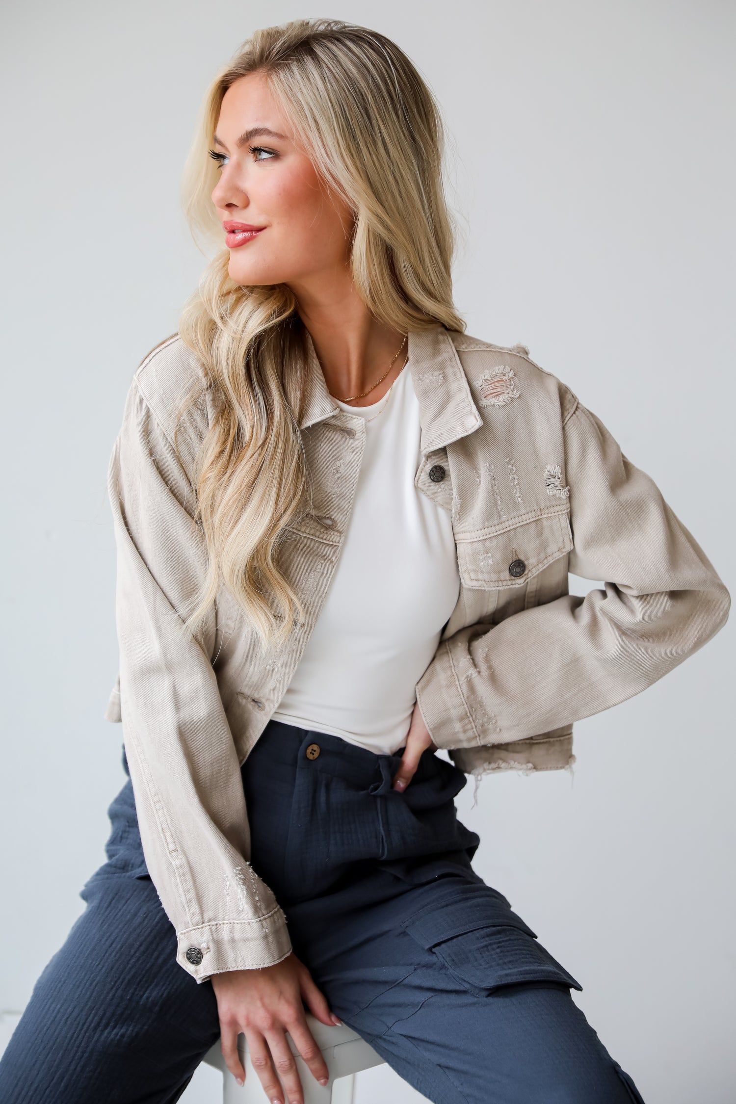 Definite Icon Taupe Distressed Cropped Denim Jacket is lighweight, mid-crop fit, and the perfect spring layer. Taupe jacket. spring jacket.