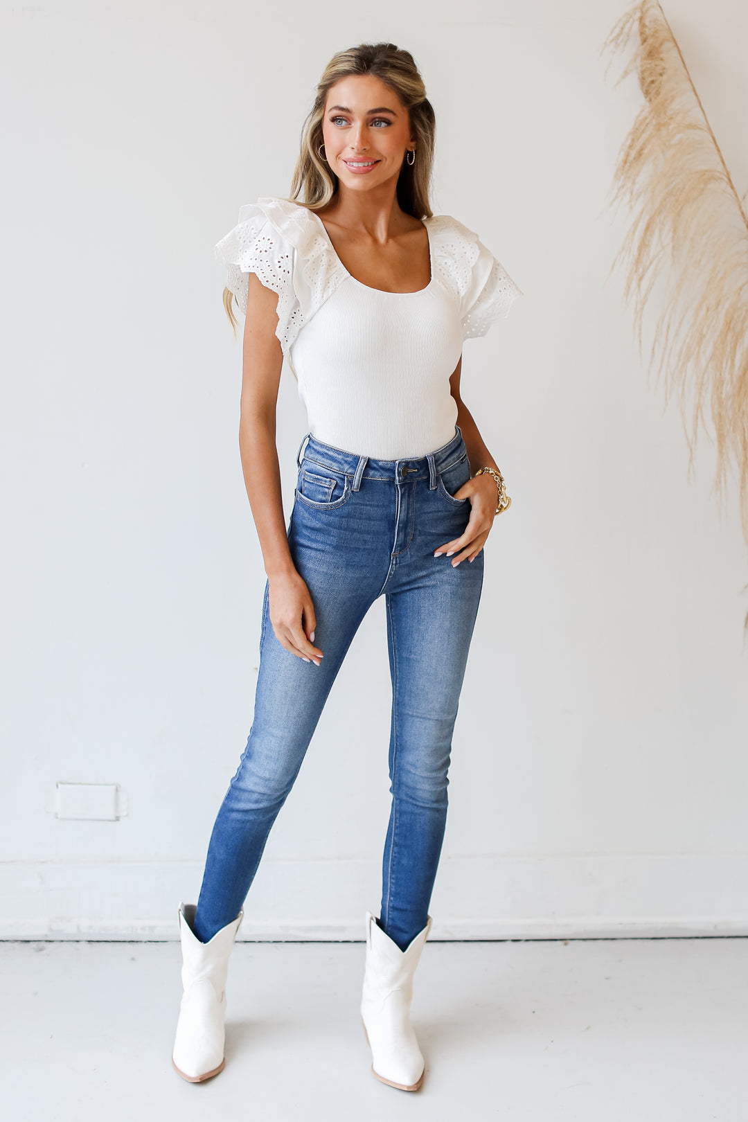 model wearing a white Eyelet Ruffle Sleeve Top with skinny jeans