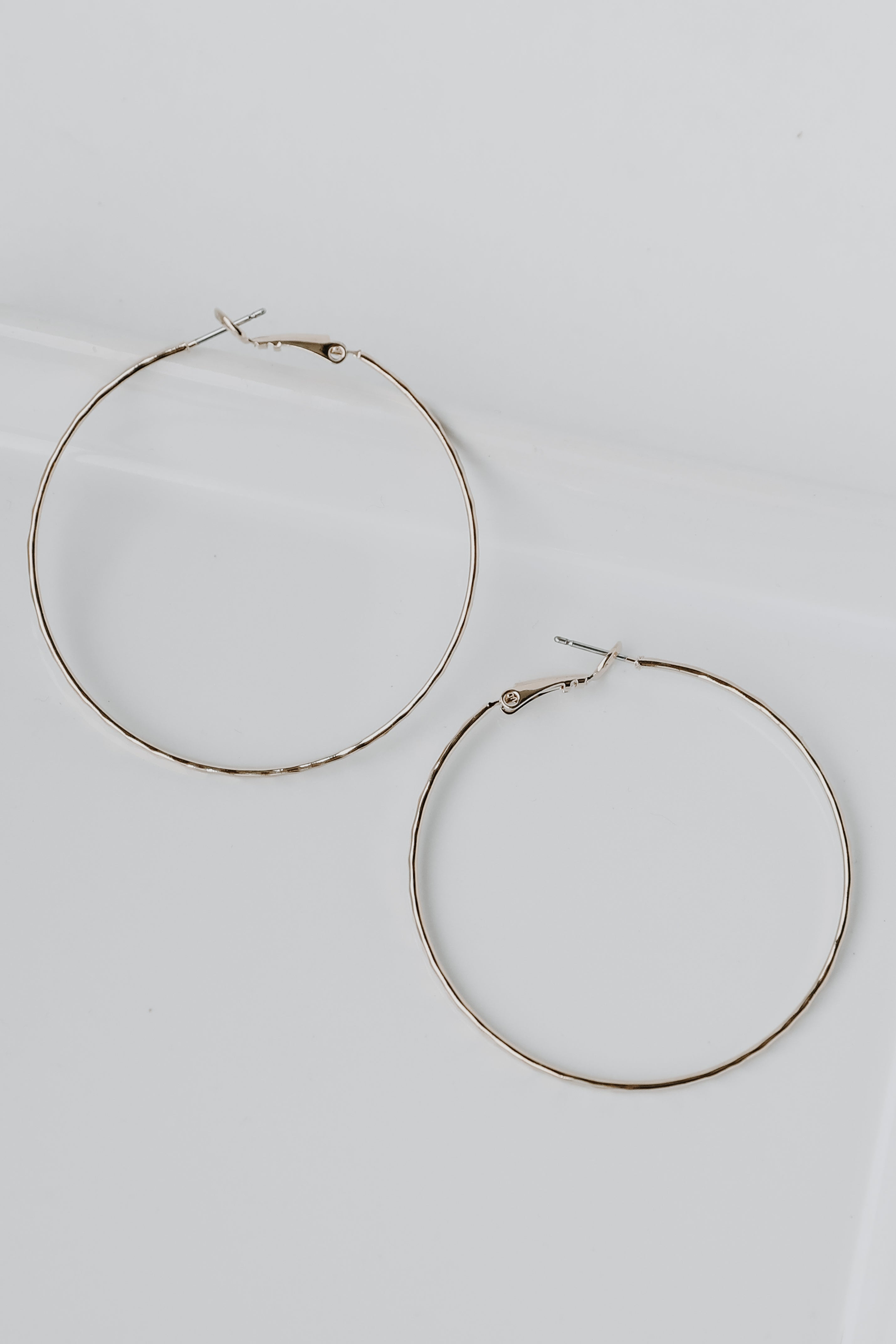 Hammered Hoop Earrings in gold flat lay