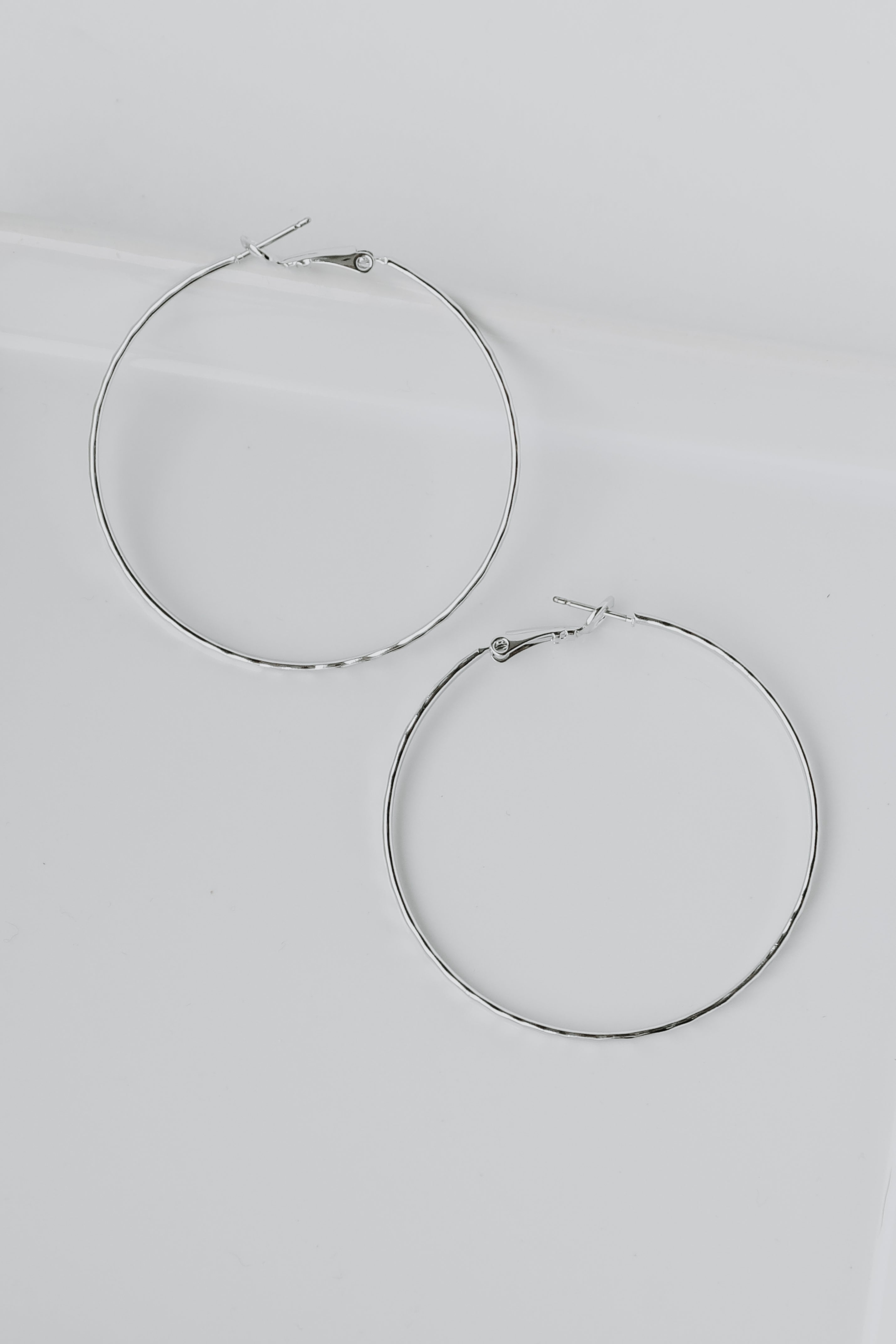 Hammered Hoop Earrings in silver flat lay