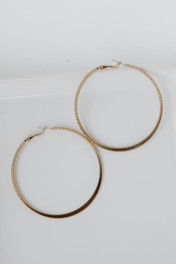 Gold Textured Medium Hoop Earrings flat lay